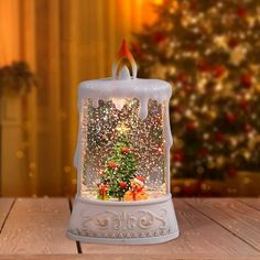 a christmas tree in a snow globe on a table