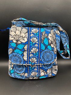 "Perfect purse for your winter vacation to warmer climate! Charming Blue Bayou crossbody shoulder bag in a signature Vera Bradley fabric!  True classic Vera Bradley with insignia on the hardware and fabric and zipper pulls.  Blue, white, black florals with same colours in zigzag lining.  Age related wear but no rips, tears, stains or damage.   Measures:  12\" high, 11.5\" wide, 38\" long when adjustable fabric strap is extended full length.  Please examine photos carefully for condition; any damage or age related wear is always detailed in the description." Blue Travel Backpack Shoulder Bag, Blue Shoulder Bag For Travel, Blue Bags With Cell Phone Pocket For On-the-go, Blue Bag With Cell Phone Pocket For On-the-go, On-the-go Blue Bag With Cell Phone Pocket, Blue Rectangular Travel Satchel, Blue School Shoulder Bag With Adjustable Strap, Vintage Blue Satchel For Travel, Blue Satchel Shoulder Bag For Travel