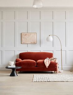 a living room with a red couch and white walls