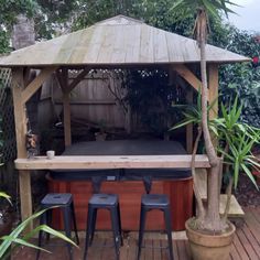 an outdoor hot tub with three stools and a table in the middle of it