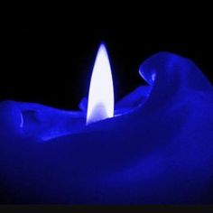 a blue candle is lit in the dark