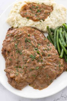 a plate with mashed potatoes, green beans and gravy