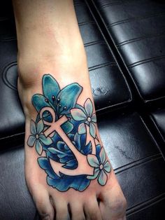 a foot with an anchor and flowers on it