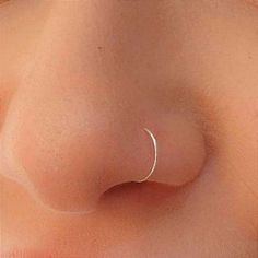 a woman's nose is shown with an open nose ring on top of it