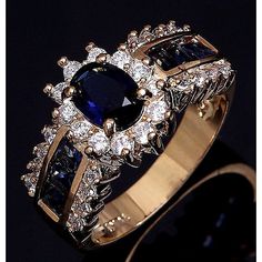 a gold ring with blue and white stones on it's sides, in front of a black background