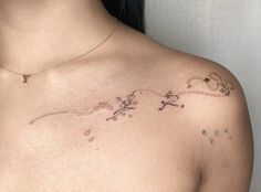 a woman's chest with flowers on it and a cross tattooed on the side