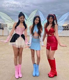 three young women dressed in costumes standing next to each other