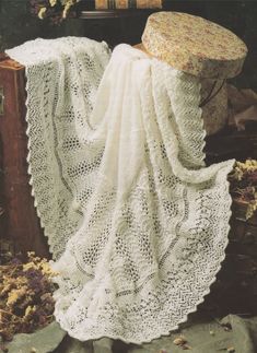 a white crocheted blanket sitting on top of a table