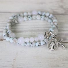 The Glory bracelet, named after the white vestments Priest wear during Feast days, has a combination of kiwi jaspers and snow quartz, and is strung on the most durable elastic cord. The bracelet comes with the (re)movable prayer "bookmark" charm if you'd like to keep track of your rosary as you pray throughout the day.The Glory style bracelet comes in two sizes: small and medium. The small size contains a full five decades, but omits the first Our Father and three Hail Mary beads. The medium siz Liturgical Colours, Snow Quartz, Rosary Bracelet, Hail Mary, White Howlite, Small Crosses, Catholic Gifts, The Glory, Gemstone Bracelets