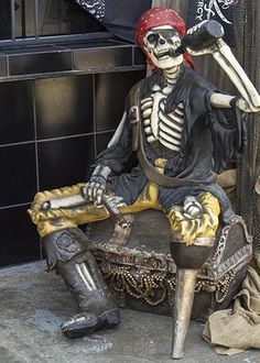 a statue of a skeleton sitting on top of a chair