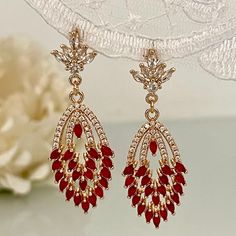 These Art Deco cubic zirconia earrings red dazzle with their shine and beauty. Handmade by me in my small home workshop. The materials are chosen with love and care, always seeking quality and elegance. This model is ideal for that special occasion for you or to give as a gift. The materials of these incredible wedding Art Nouveau earrings are 18k plated gold in a beautiful champagne color. The post is made of 925 silver and the nut is 925 silver plated in 14k gold. The posts of these earrings a Elegant Red Bridal Earrings For Party, Elegant Red Drop Crystal Earrings, Red Dangle Bridal Earrings, Formal Red Sparkling Jewelry, Elegant Red Crystal Earrings, Red Crystal Formal Earrings, Red Dangle Chandelier Earrings For Anniversary, Red Sparkling Stones Drop Earrings, Ruby Chandelier Drop Earrings For Party