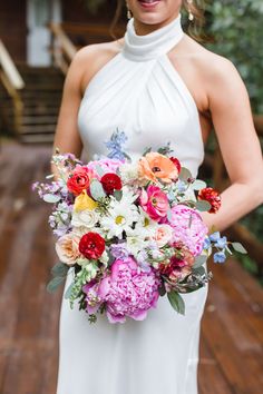 a woman in a white dress holding a bouquet of flowers