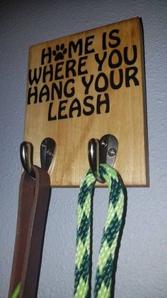 there is a sign on the wall that says home is where you hang your leash