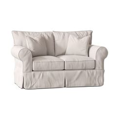 a white couch with two pillows on it's back and one arm folded up