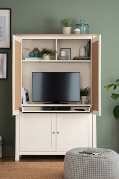 a living room with green walls and a white entertainment center