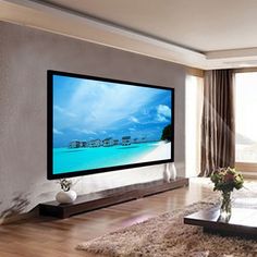 a large flat screen tv mounted on the wall in a living room next to a window