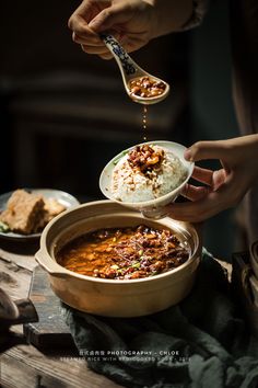 a person is spooning some food out of a bowl with rice and other foods