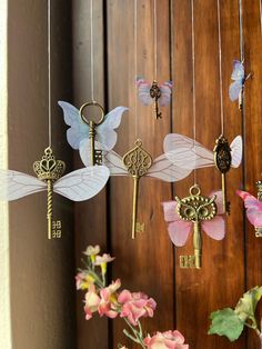 a bunch of keys that are hanging from a string on a door with flowers in the foreground