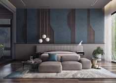 a modern bedroom with wood floors and blue accent wallpaper, along with a large gray couch