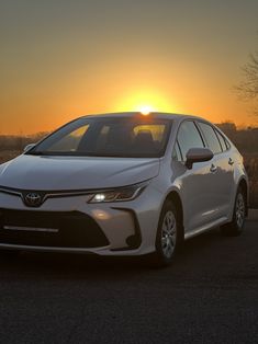 a white car parked in front of the sun