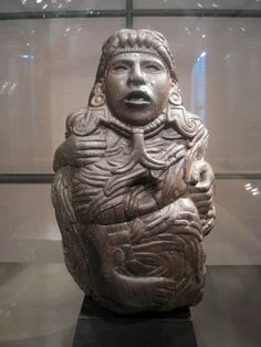 an ancient statue is on display in a glass case