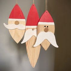 two wooden santa claus ornaments hanging from strings