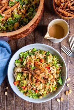 a bowl filled with salad next to two bowls full of food