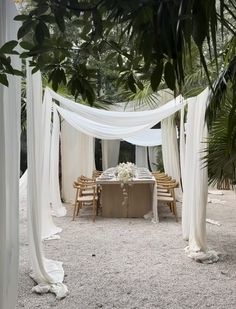 an outdoor dining area with white drapes and tables