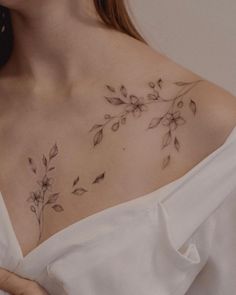 a woman's chest with flowers and leaves on it