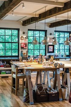 a room with lots of windows and wooden tables in front of them, along with various items on the floor