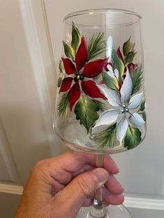 a hand holding up a wine glass decorated with flowers