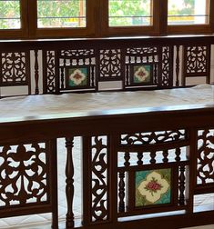 an intricately carved wooden bed frame with decorative tiles on the top and bottom panels