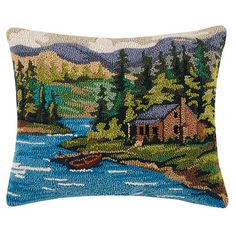 a decorative pillow with an image of a cabin on the water and mountains in the background