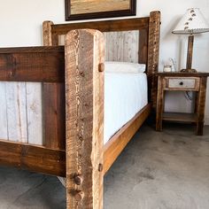 a wooden bed frame in a bedroom with two nightstands and a painting on the wall