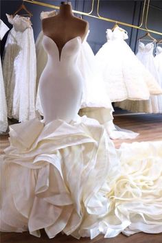 wedding gowns are displayed on mannequins in a bridal shop