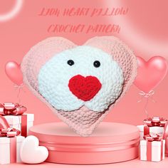 a heart - shaped crochet pattern is displayed on a pink background with presents