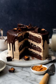 a chocolate cake sitting on top of a white plate next to a glass of milk