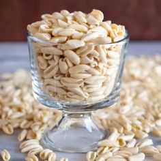 a glass bowl filled with sunflower seeds on top of a blue tablecloth and text reads homemade pasta without a pasta machine