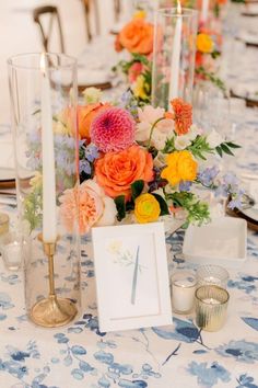 the table is set with candles, flowers and cards for guests to write their names