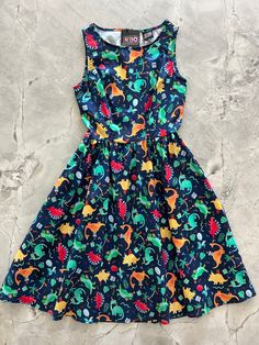 a flat lay of the front of the party dinos vintage dress Dino Dress, 1950s Inspired Dress, Quirky Dress, Dinosaur Dress, Prom Outfit, Skirt Pockets, Dino Party, Rockabilly Fashion, Teacher Style