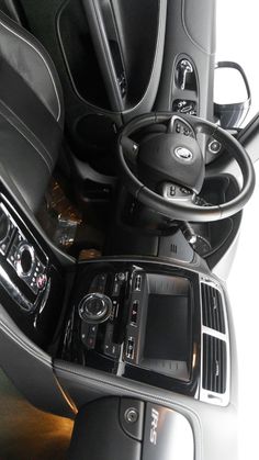 the inside of a car with steering wheel controls and other electronics in it's center console