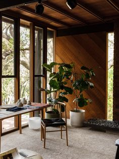 a living room filled with lots of windows next to a wooden table and two chairs