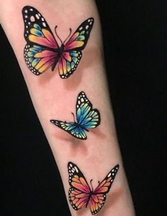 three colorful butterflies on the arm