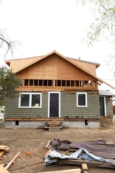 a house being built in the middle of a construction area with wood framing on the roof