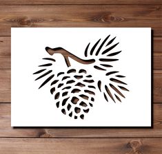 a paper cutout of a pine cone on a wooden table with wood planks