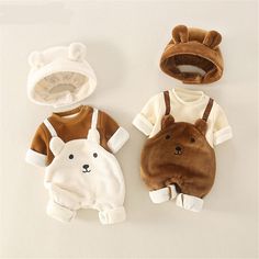 three pieces of baby clothing with bear and bear ears on the front, one is brown and