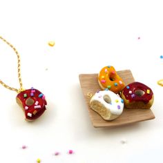 three miniature donuts on a wooden plate with confetti sprinkles