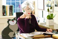 a woman sitting at a desk in front of a laptop computer with a paper cut out of a cat on it