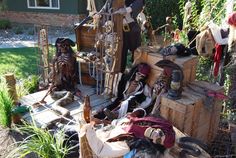 an assortment of pirate items on display in front of a house with plants and other decorations