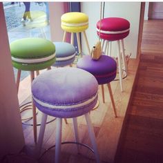 colorful stools are lined up in a room